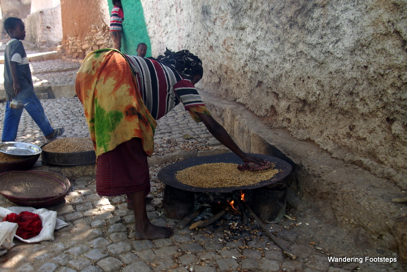 A woman roasting grain for sale at the market.