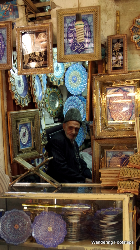 Typical Persian decoration and colors on this old man's goods for sale.