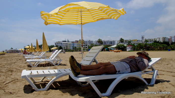 Bruno contentedly taking a nap along the beach.  Note the string of hotels in the background.