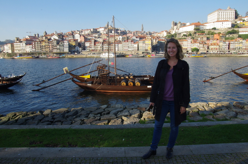 Me posing on the south side of Porto's stretch of the Douro River, with Ribeira and the wine-barrel-loaded boats in the backdrop.