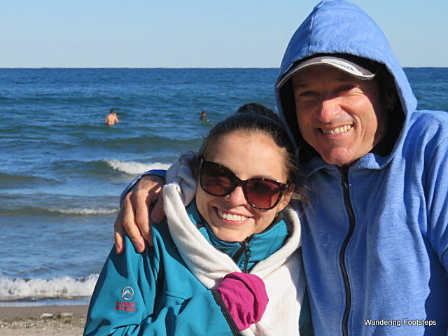 Our foreigners are freezing their buns off and, behind, there is someone swimming in Lake Ontario!!