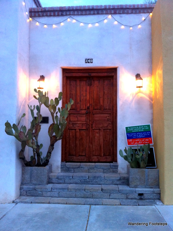 The sign to the right of this adorable door is the trilingual welcome sign I saw all over the city.