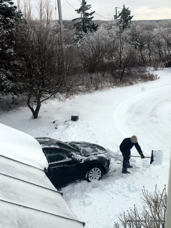 Shoveling the car free from the snow so we can go to town.